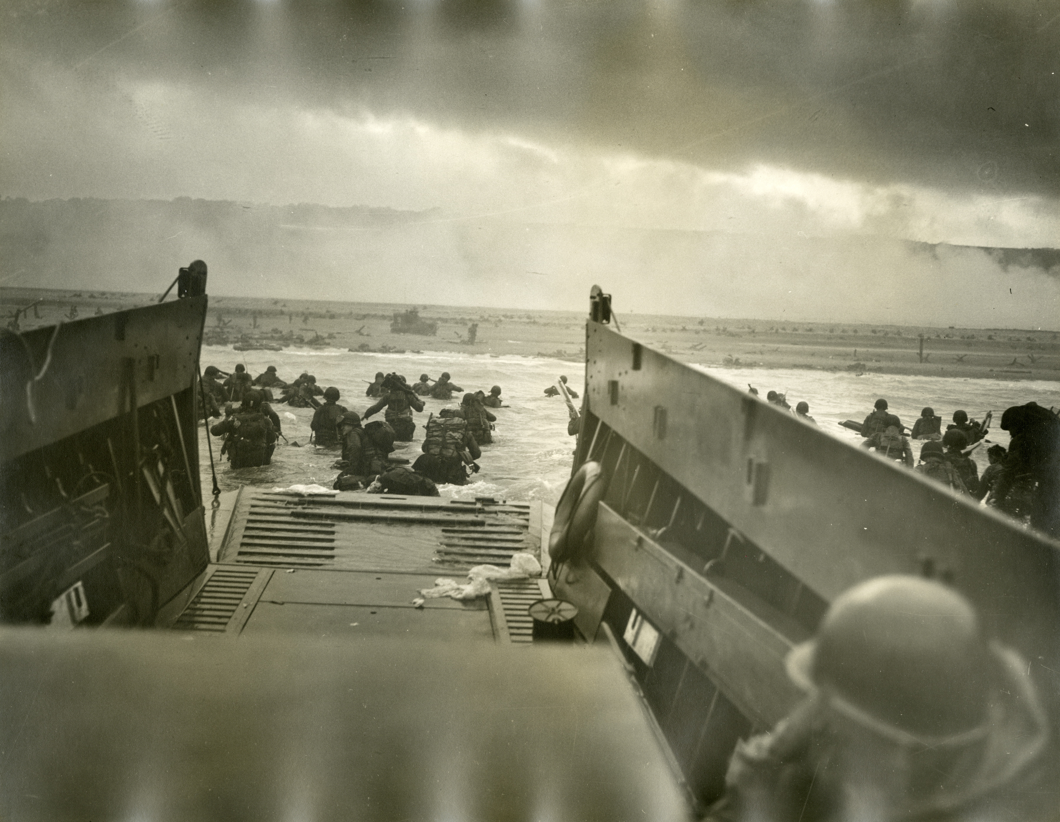 American Soldiers Wade From A Landing Craft Towards Omaha Beach D