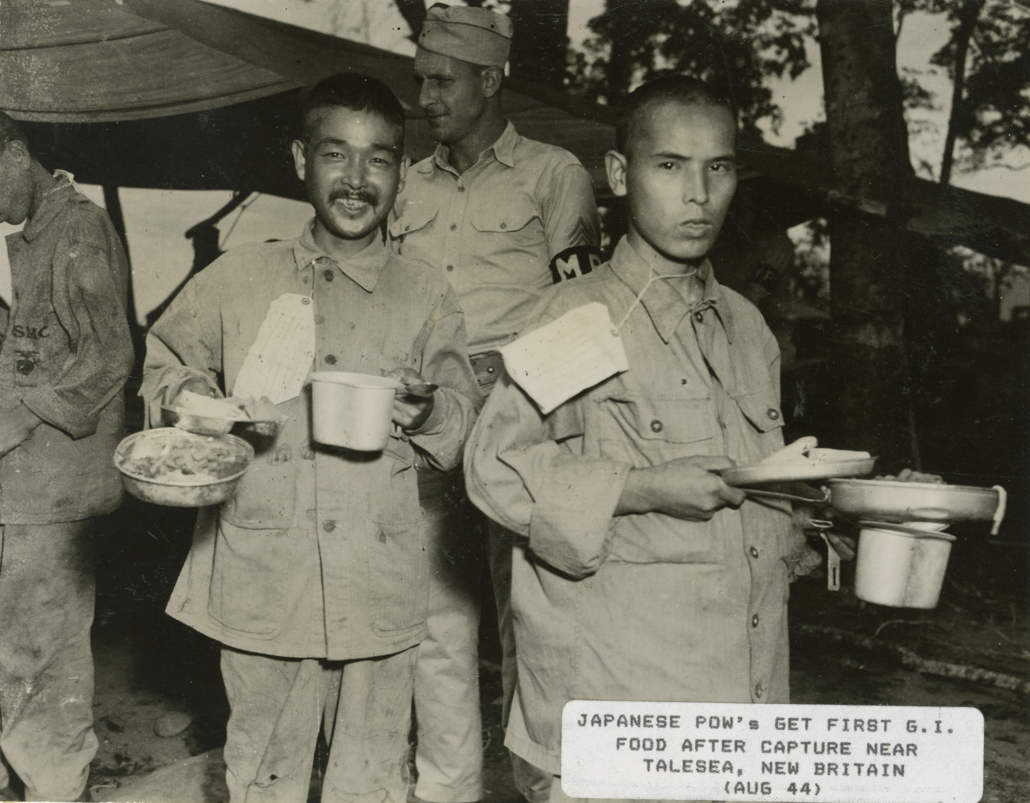 Japanese prisoners of war in USMC uniforms carry mess kits ...