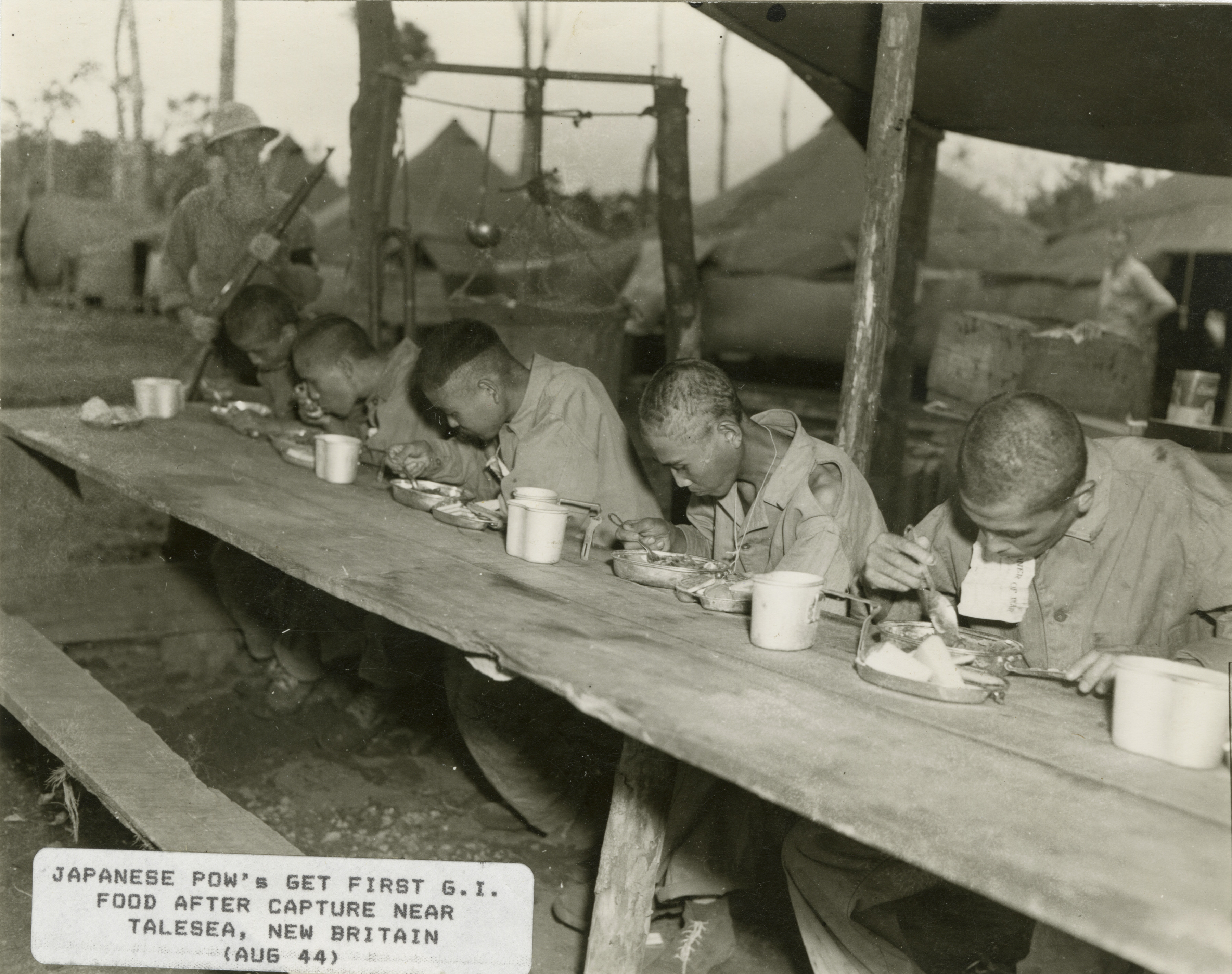 Several Japanese Prisoners Of War Eat Meals From US Mess Kits Near 