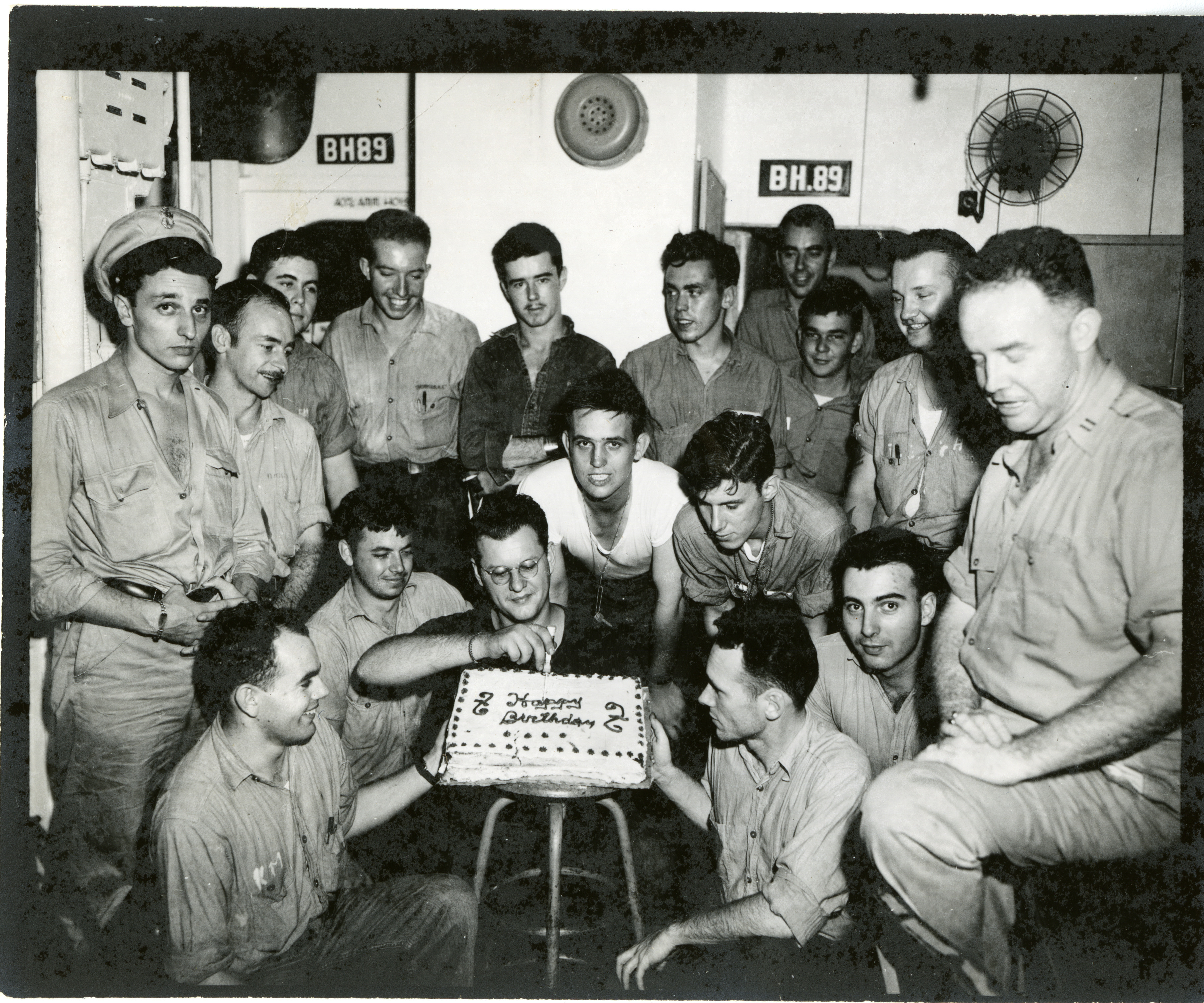 Marineros uniformados posando con pastel de cumpleaños a bordo del USS Hancock ...