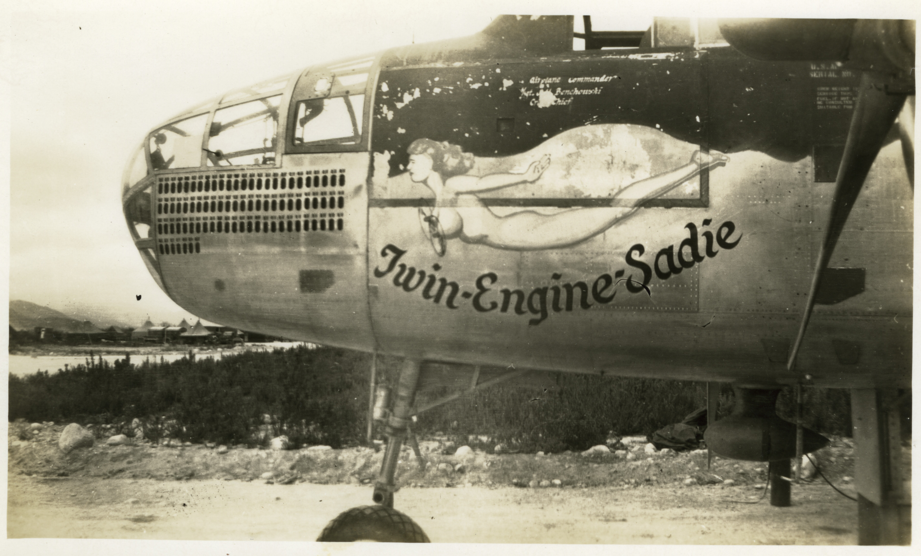 Nose art on B-25 Mitchell bomber; naked woman with propellers on breasts an...