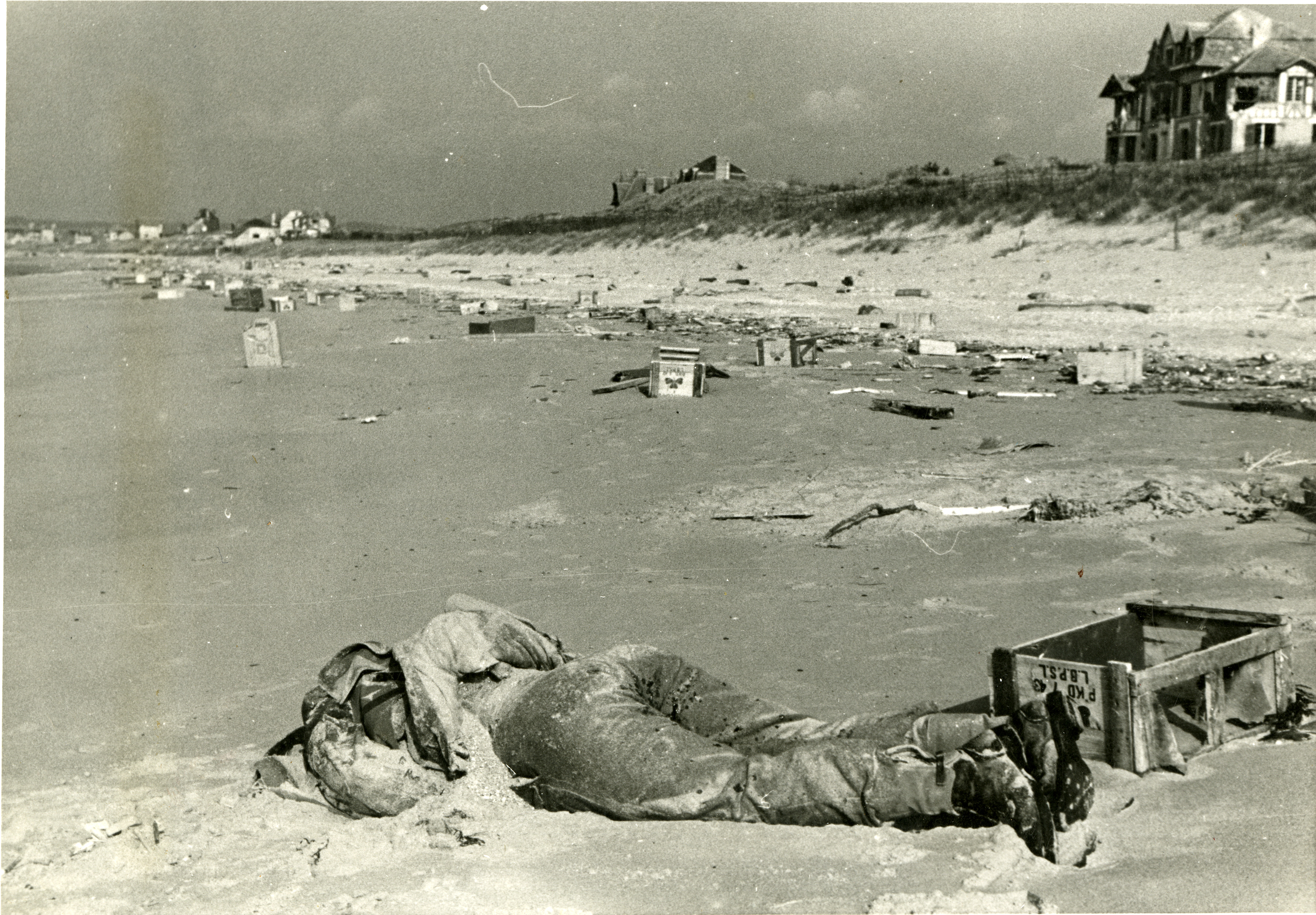 Dead British soldier washed up on littered Normandy beach, France, 1944 ...