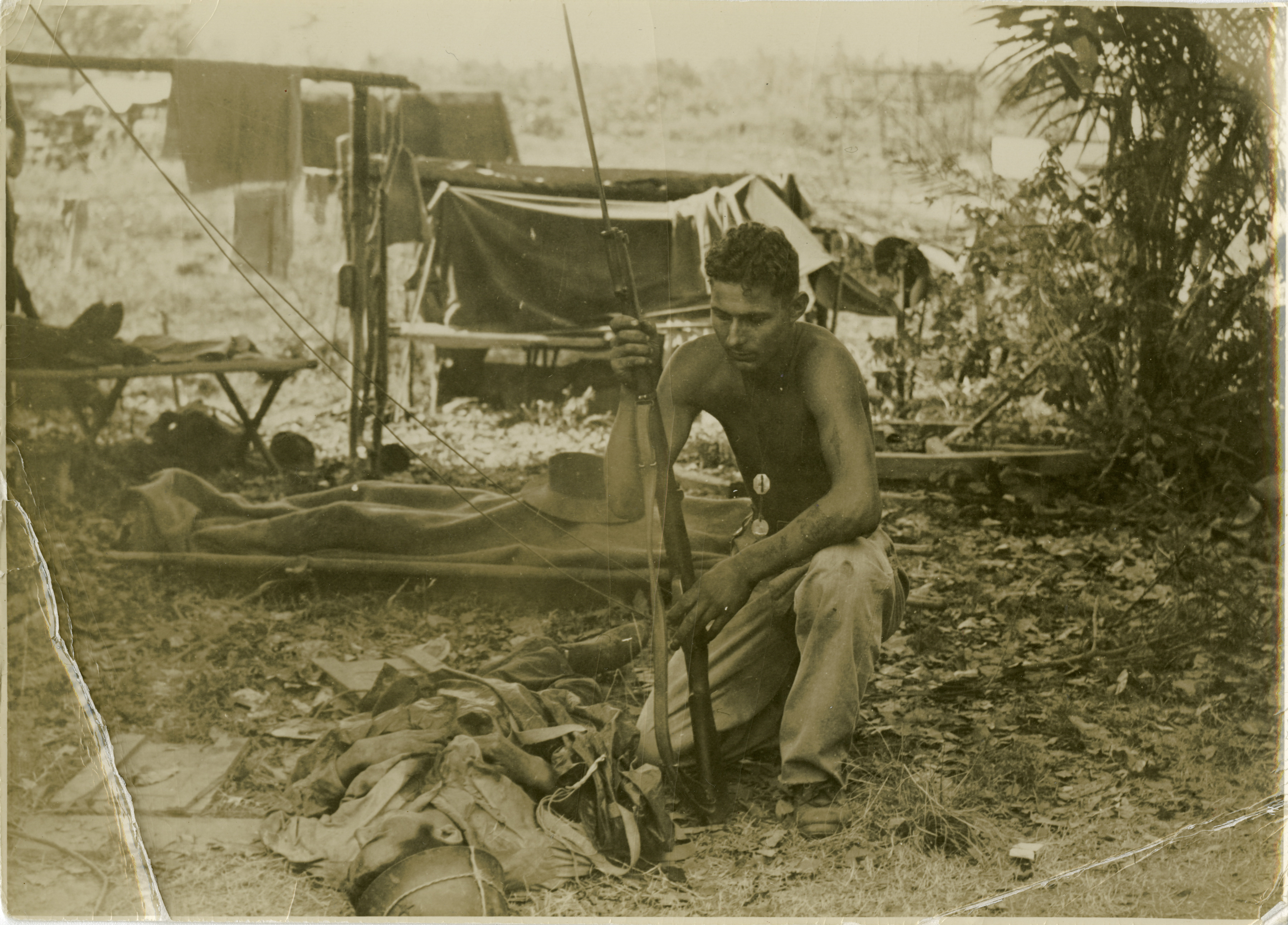 Australian soldier kneeling next to body of a dead Japanese soldier on ...