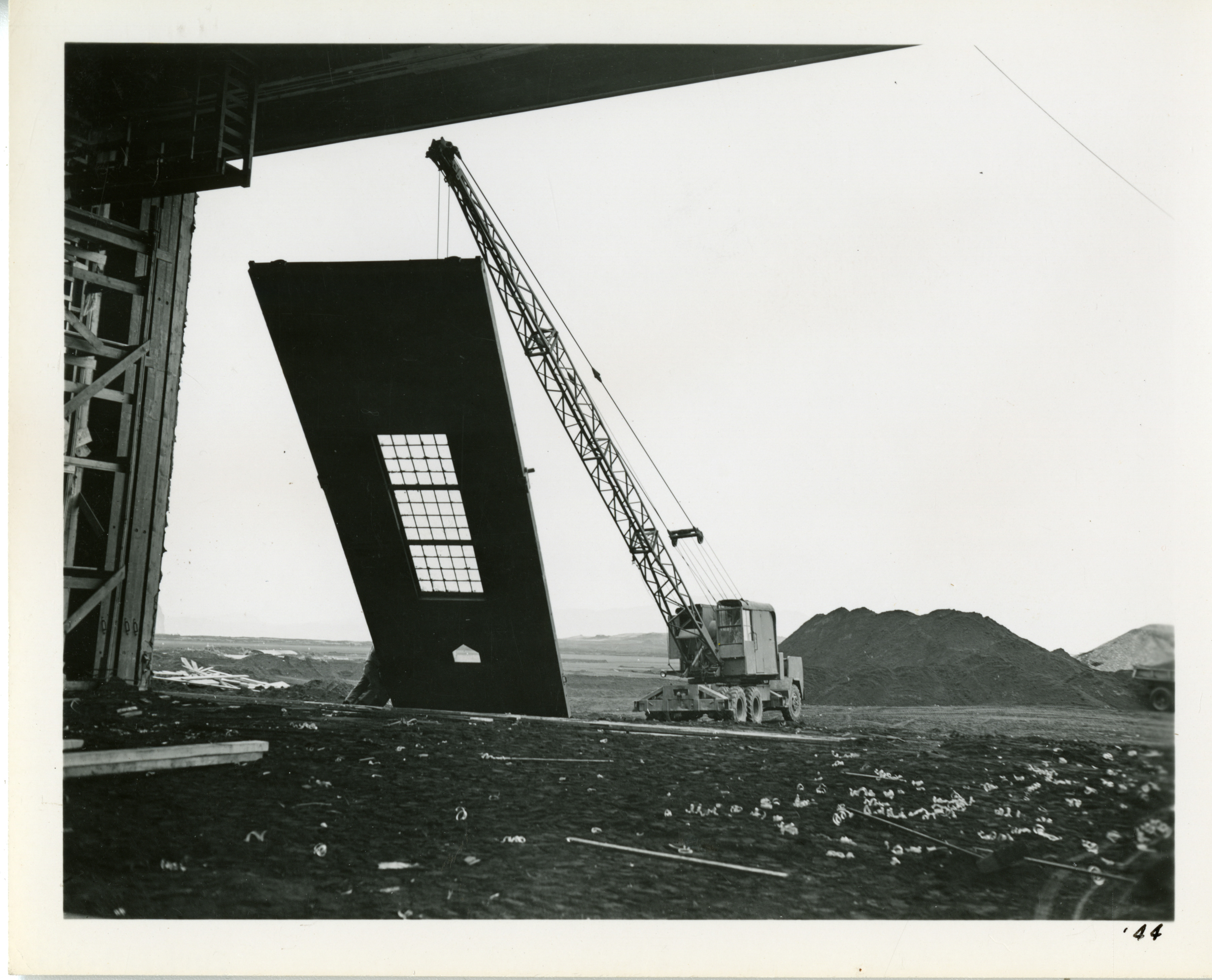 Crane raises up a prefabricated wall during the construction of an ...